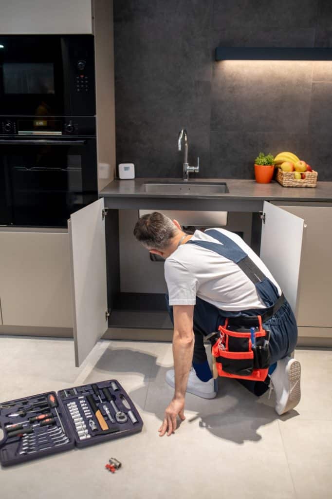 back-view-man-crouching-near-kitchen-sink [1600x1200]